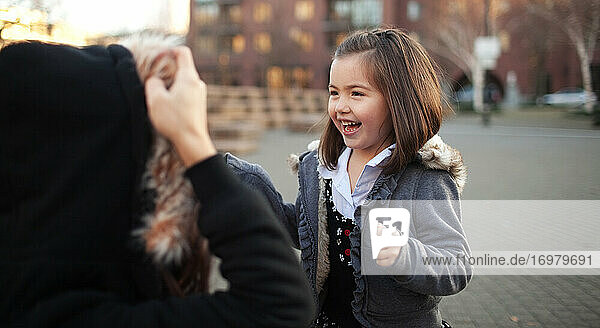 Young girl laughing at somthing her mother is doing