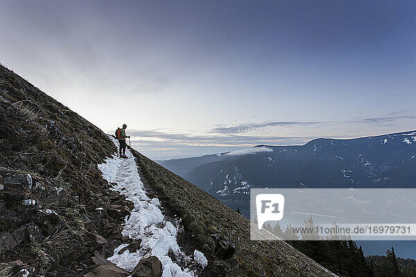 A young man climbs to the top of Dog Mountain in the Columbia Gorge.