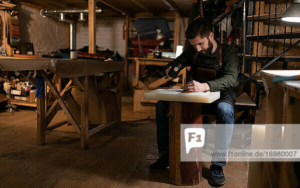 Bärtiger Handwerker bei der Herstellung von Lederhandwerk