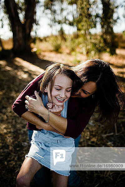 Mother Embracing Laughing Daughter at Park in Chula Vista