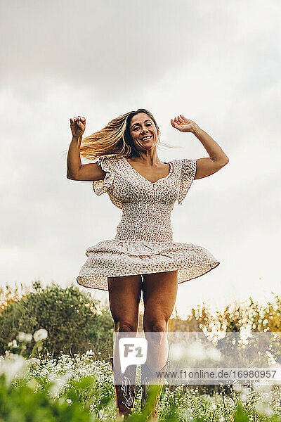 Happy Woman Wearing Dress Dancing In Nature