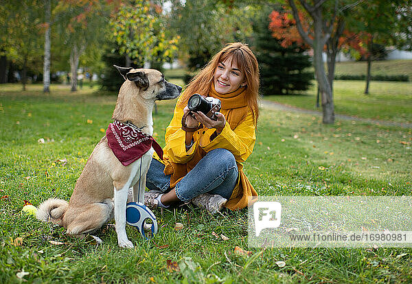 Lächelnde Dame schießt süßen Hund im Park