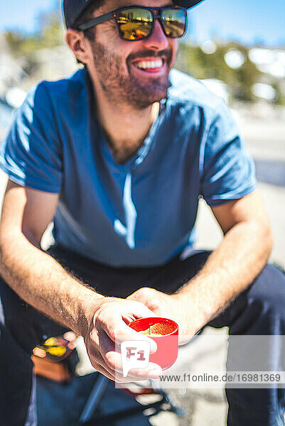 Man smiling and drinking espresso from portable espresso maker