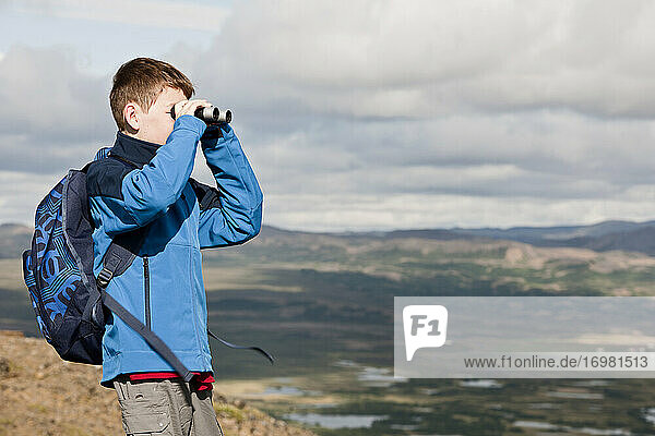 boy surveying the landscape at lake Myvatn with his binoculars