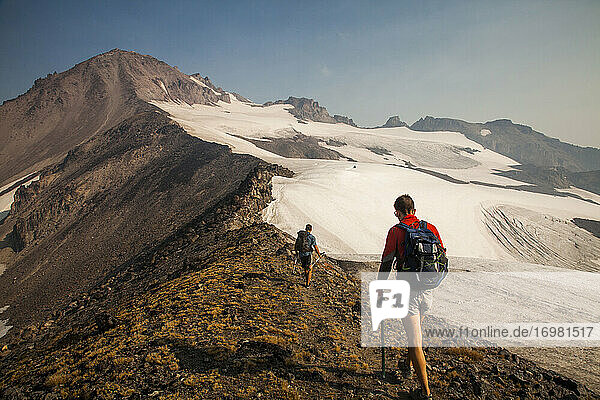 Two hikers climb to towards the summit of Glacier Peak in Washington.