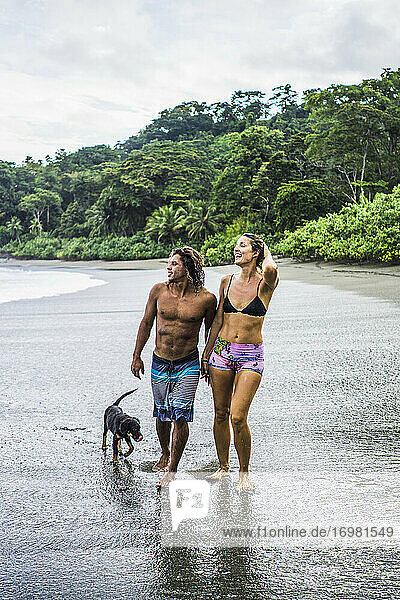 Multiethnisches Paar auf Costa Rica-Urlaub spaziert am Strand