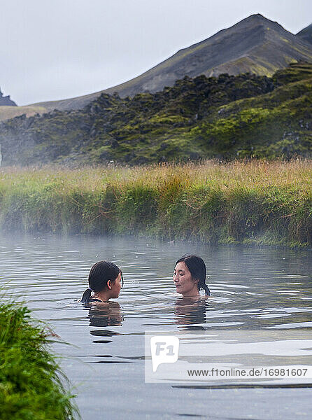 Mutter und Tochter nehmen ein Bad in einer geothermischen Quelle in Island