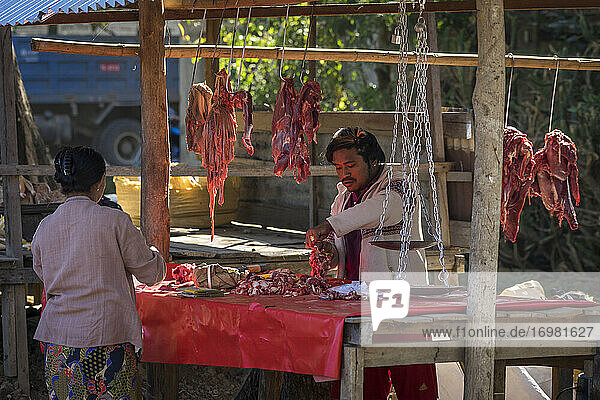 Mann verkauft Fleisch auf dem Straßenmarkt in einem Dorf am Inle-See  Nyaungs