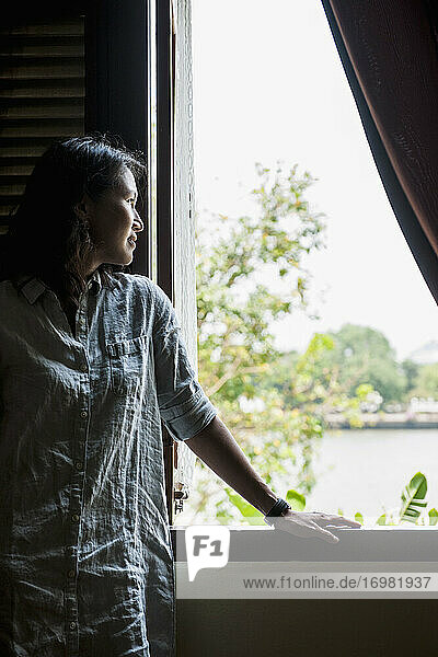 schöne Frau schaut aus dem Fenster in Bangkok