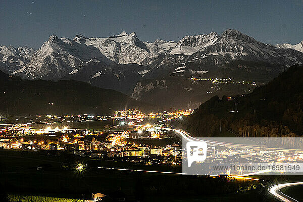 Stadt bei Nacht mit Lichtern auf mit Bergen im Hintergrund