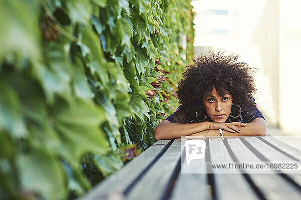 Eine schöne Frau  die in einem Park liegt und schönes Afro-Haar hat.