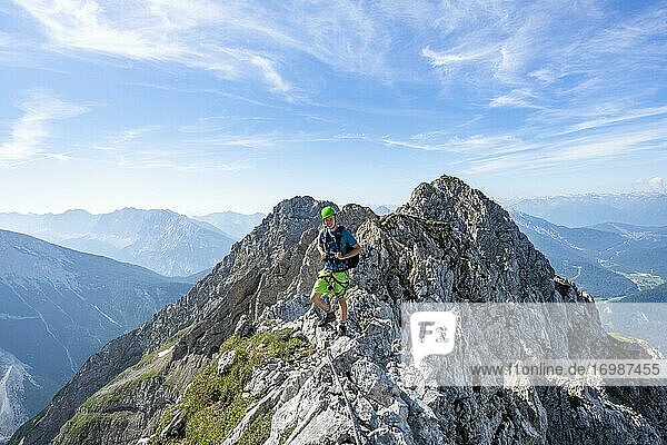 Bergsteiger auf einem Grat an einem gesicherten Klettersteig  Mittenwalder Höhenweg  Karwendelgebirge  Mittenwald  Bayern  Deutschland  Europa