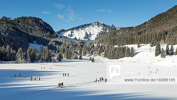 Frozen Spitzingsee in winter with people  in the back Brecherspitz  Spitzingsee  Schliersee  Bavaria  Germany  Europe
