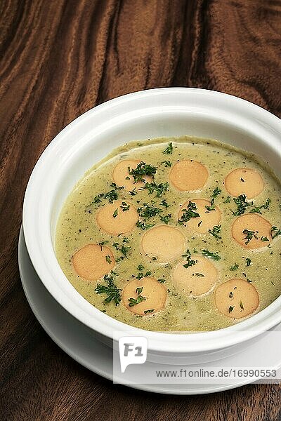 German traditional KARTOFFELSUPPE potato and sausage soup on wood table background.