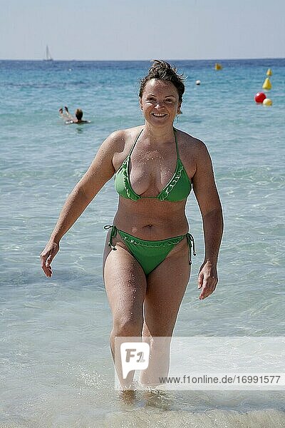Frau beim Baden im Mittelmeer. Strandleben am Playa Son Xoriguer in Cala'n Bosch auf Menorca. Spanien.