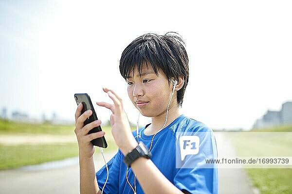 Happy Japanese teenager enjoying himself outdoors