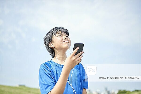 Happy Japanese teenager enjoying himself outdoors