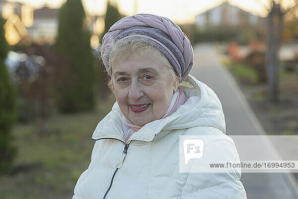 Portrait happy beautiful senior woman in winter coat on sidewalk
