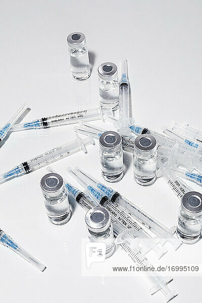 COVID-19-Impfstoff-Fläschchen und Spritzen auf weißem Hintergrund