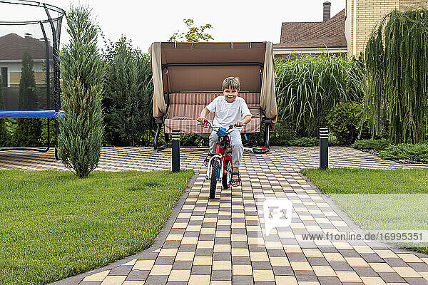 Porträt glücklich Junge Fahrrad fahren im Hinterhof