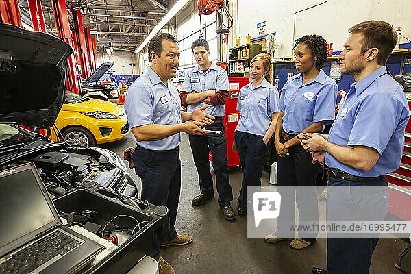 Männer und Frauen mit unterschiedlichem ethnischen Hintergrund  ein Team von Mechanikern in einer Autowerkstatt