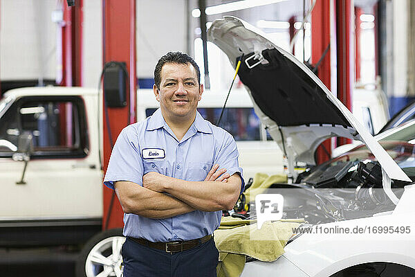 Porträt eines hispanischen männlichen Mechanikers in einer Autowerkstatt