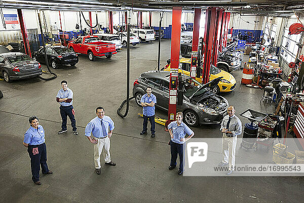 Porträt von sechs Mechanikern in einer Autowerkstatt von oben gesehen