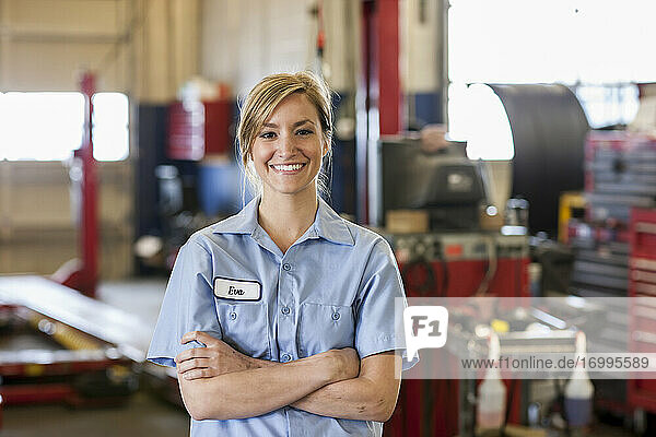 Portrait of young female Caucasian mechanic in auto repair shop