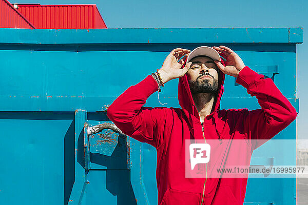 Young man wearing red hoodie  facing the sun
