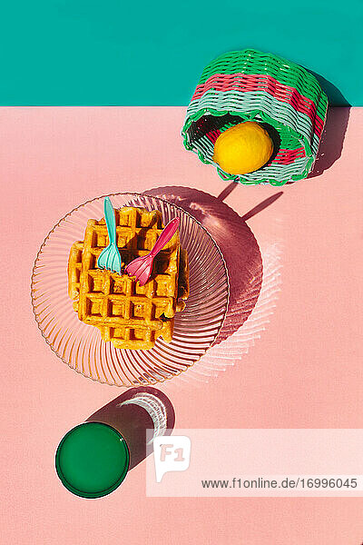 High angle view of waffle  lemon in basket  juice kept on table