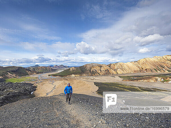 Lone hiker walking toward camera in Landmannalaugar