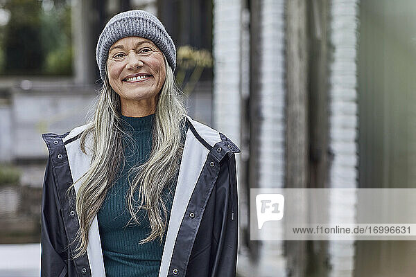 Glückliche reife Frau mit grauem Haar im Hinterhof