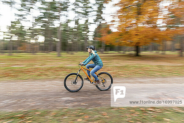Mid adult woman riding bicycle at Cannock Chase