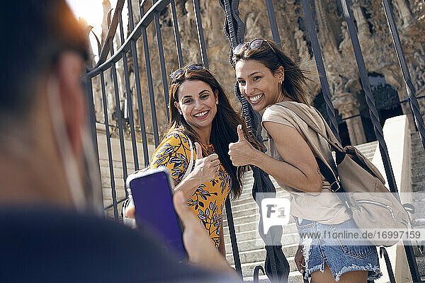 Mann  der ein Touristenfoto mit seinem Mobiltelefon macht  während er vor der Sagrada Familia in Barcelona  Katalonien  Spanien steht