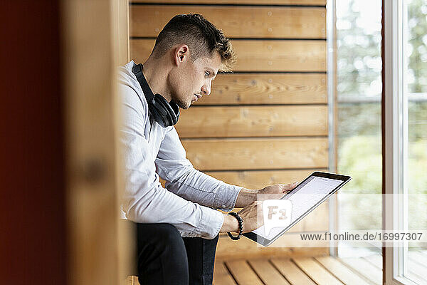 Young man using digital tablet while sitting at home