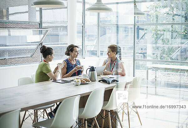 Weibliche Fachkräfte diskutieren im Sitzungssaal bei einem Kaffee im Büro