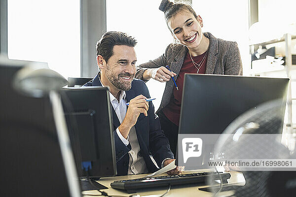 Geschäftsleute  die einen Computer benutzen  während sie im Büro zusammenarbeiten