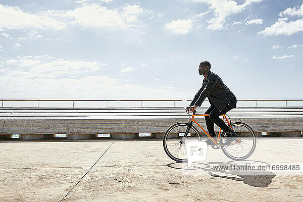 Man riding bike on waterfront promenade