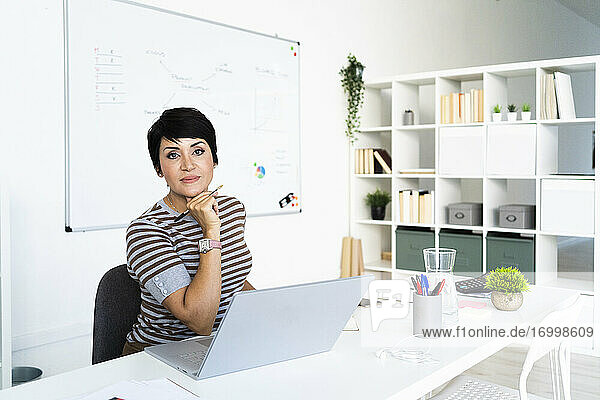 Porträt einer Geschäftsfrau bei der Arbeit im Büro vor einem Laptop