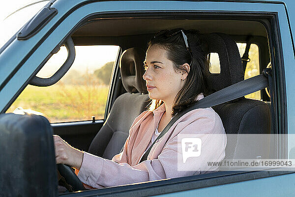 Young woman driving car on road trip