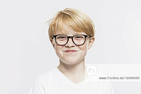 Lächelnder Junge mit Brille vor weißem Hintergrund