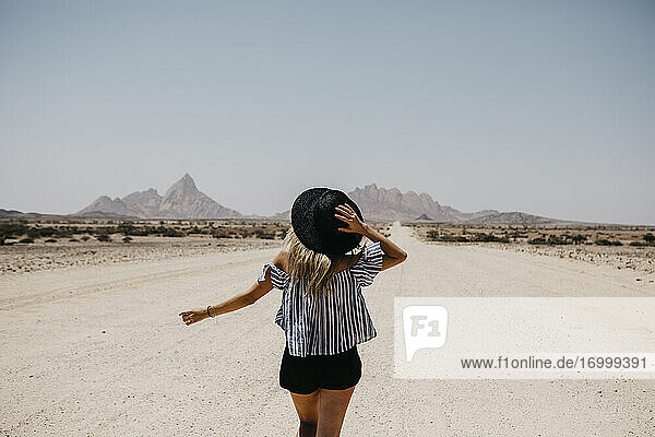 Namibia  woman walking on the road to Spitzkoppe
