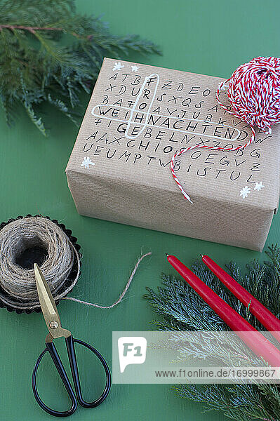 Schere  Schnur und Wortsuchrätsel auf verpacktem Weihnachtsgeschenk