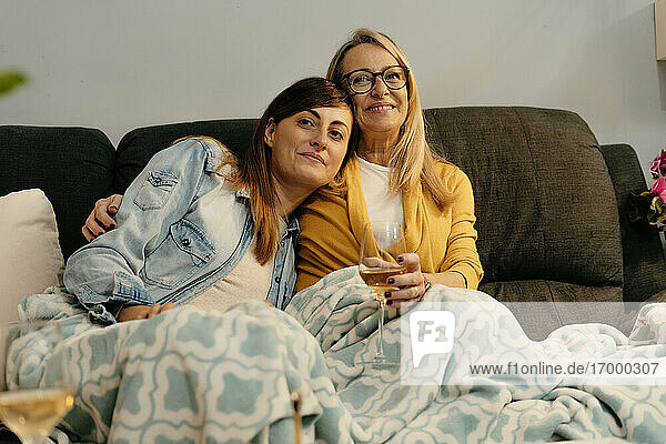 Senior woman sitting with her daughter on sofa at home