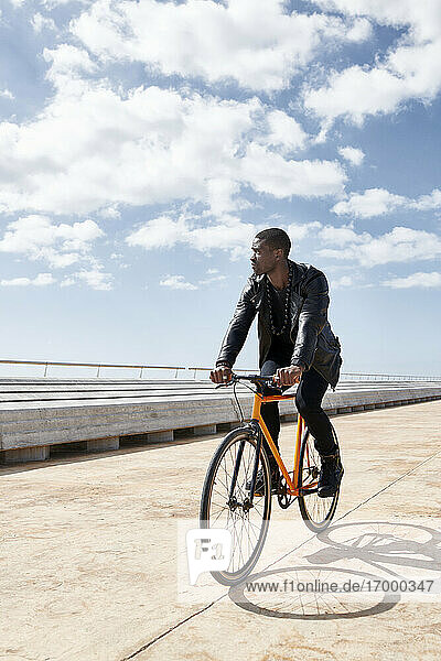 Mann fährt Fahrrad auf der Uferpromenade