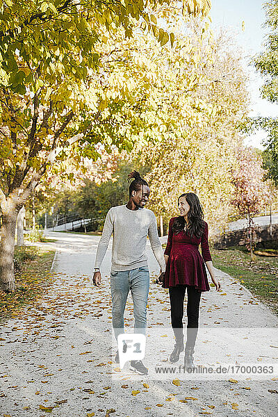 Happy couple holding hands while walking in park