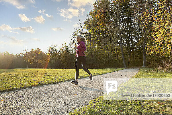 Aktive reife Frau läuft im öffentlichen Park