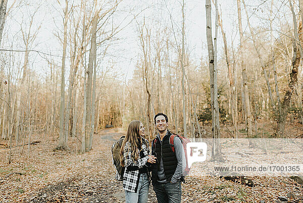 Junges Paar unterhält sich bei einer Herbstwanderung im Wald