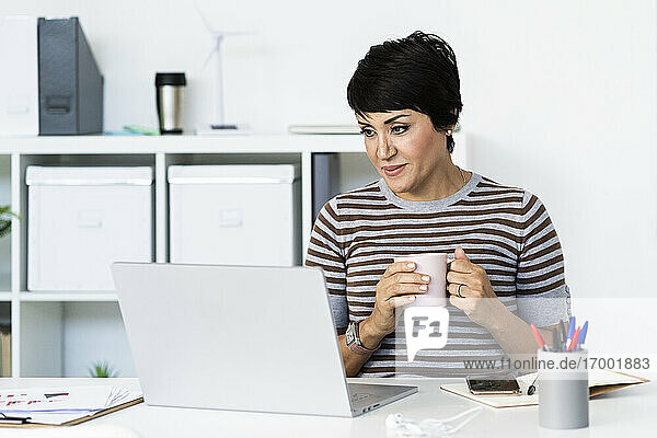 Portrait of businesswoman working at office in front of laptop