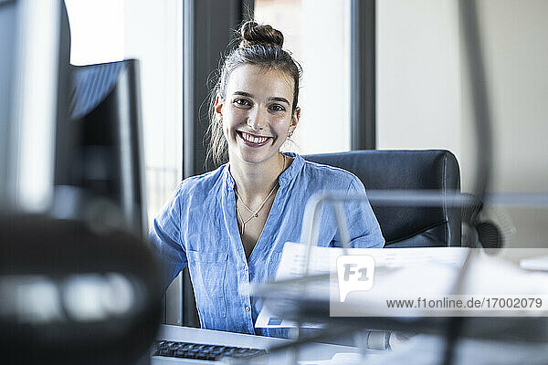 Lächelnde Geschäftsfrau im Büro sitzend